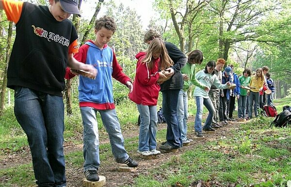 Kinder balancieren auf Baumstämmen