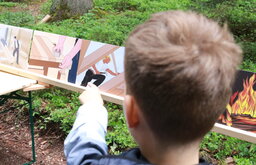 ein Junge  zeigt auf Bilder